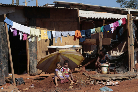 Two children sit in front of their home in the Santa Luzia slum, in Brasilia May 30, 2014. REUTERS/Joedson Alves 
