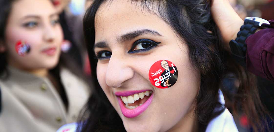 A supporter of Beji Caid Essebsi smiles with a sticker of his image on her face after he won a presidential run-off election, in Tunis December 22, 2014. REUTERS/Anis Mili 