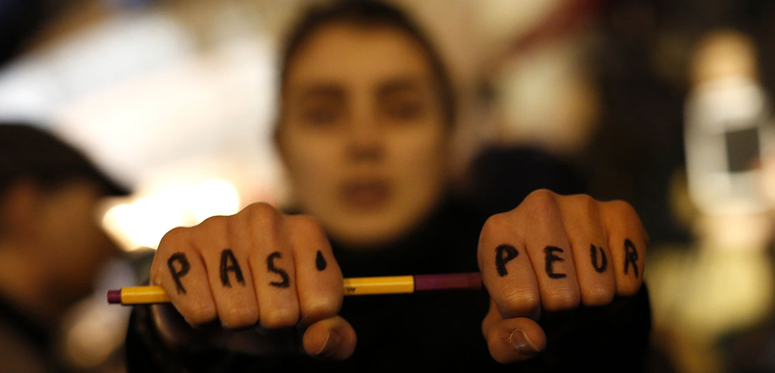 A woman is seen with "Not scared" written on her hands as she attends a vigil to pay tribute to the victims of a shooting by gunmen at the offices of weekly satirical magazine Charlie Hebdo in Paris at Republique square January 7, 2015. Hooded gunmen stormed the Paris offices of the weekly satirical magazine known for lampooning Islam and other religions, shooting dead at least 12 people, including two police officers, in the worst militant attack on French soil in decades. REUTERS/Youssef Boudlal