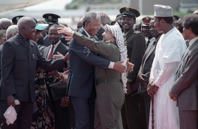 Lusaka, Zambia Nelson Mandela (L) is embraced by PLO leader Yasser Arafat as he arrives at Lusaka airport February 27, 1990. REUTERS/Howard Burditt