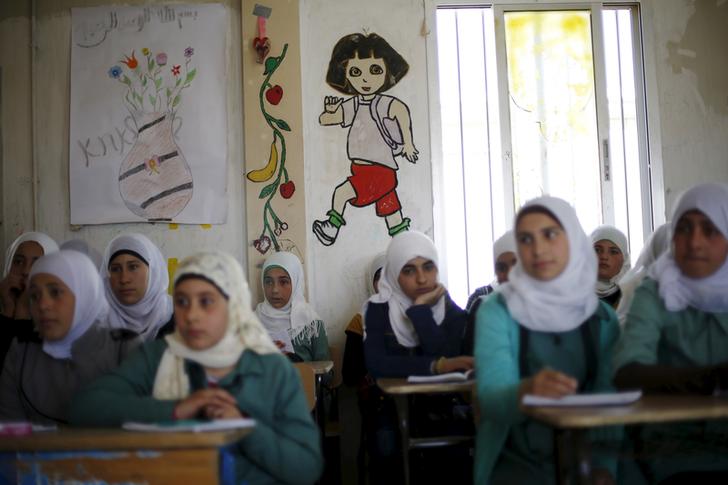 Syrian refugee students listen to their friend Omayma al Hushan, 14, who launched an initiative against child marriage among Syrian refugees, as she speaks about her initiative at a school in Al Zaatari refugee camp in the Jordanian city of Mafraq, near the border with Syria, April 21, 2016. REUTERS/Muhammad Hamed