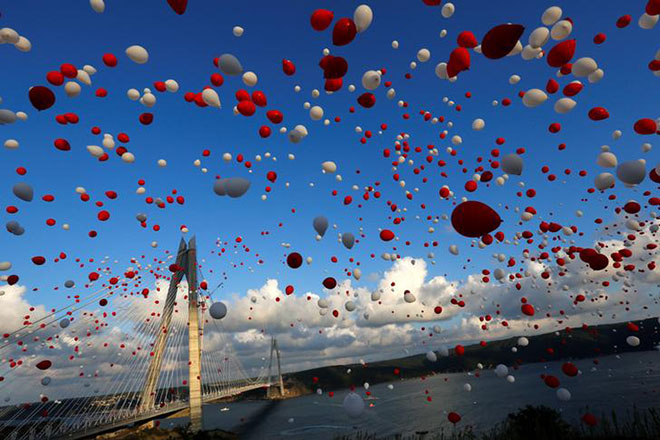 Red and white balloons are released during the opening ceremony of newly built Yavuz Sultan Selim bridge, the third bridge over the Bosphorus linking the city's European and Asian sides in Istanbul. REUTERS/Murad Sezer