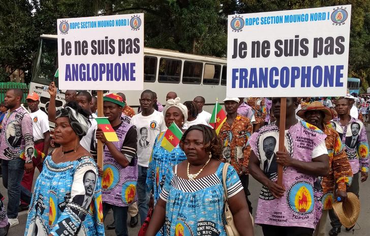 Dimostranti durante una marcia in opposizione all'indipendenza per le regioni anglofone portano cartelli con scritto "Io non sono francofono", "Io sono non anglofono ".  Douala, in Camerun il 1 ottobre 2017. REUTERS / Joel Kouam