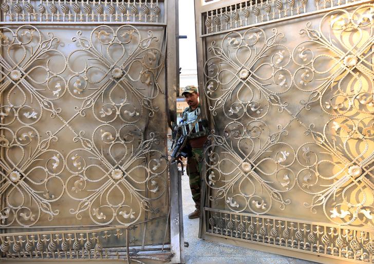 Una guardia di sicurezza afgana all'ingresso di un centro di addestramento per ostetriche dopo un attacco nella città di Jalalabad, in Afghanistan, 28 luglio 2018.REUTERS / Parwiz