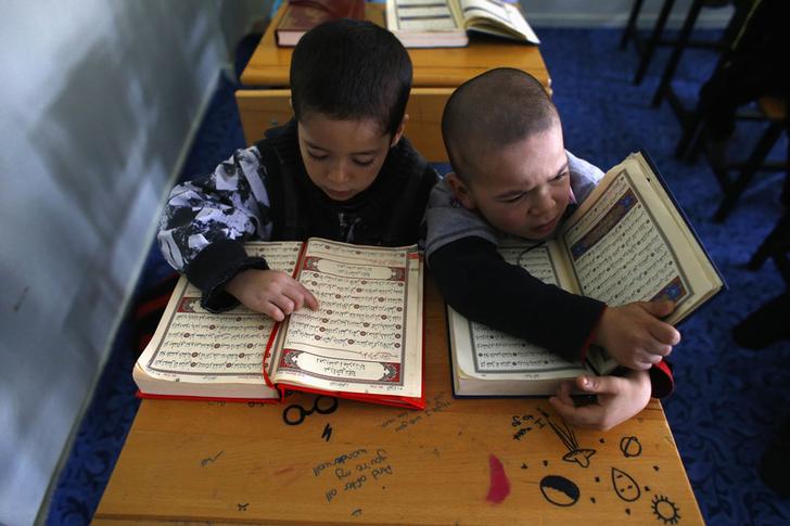 Bambini di etnia uighura leggono il Corano. REUTERS/Umit Bektas