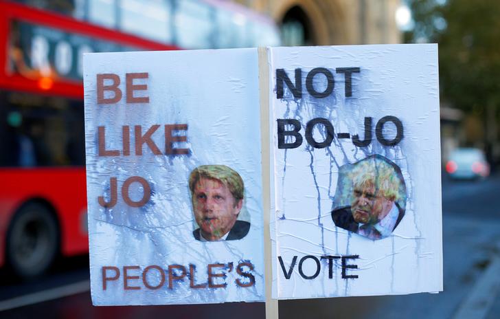 Un cartellone danneggiato dalla pioggia in favore di un secondo referendum sulla Brexit presenta le immagini dell'ex ministro degli esteri Boris Johnson e dell'ex ministro dei trasporti Jo Johnson, a Westminster, Londra, Gran Bretagna, 12 novembre 2018. REUTERS / Henry Nicholls