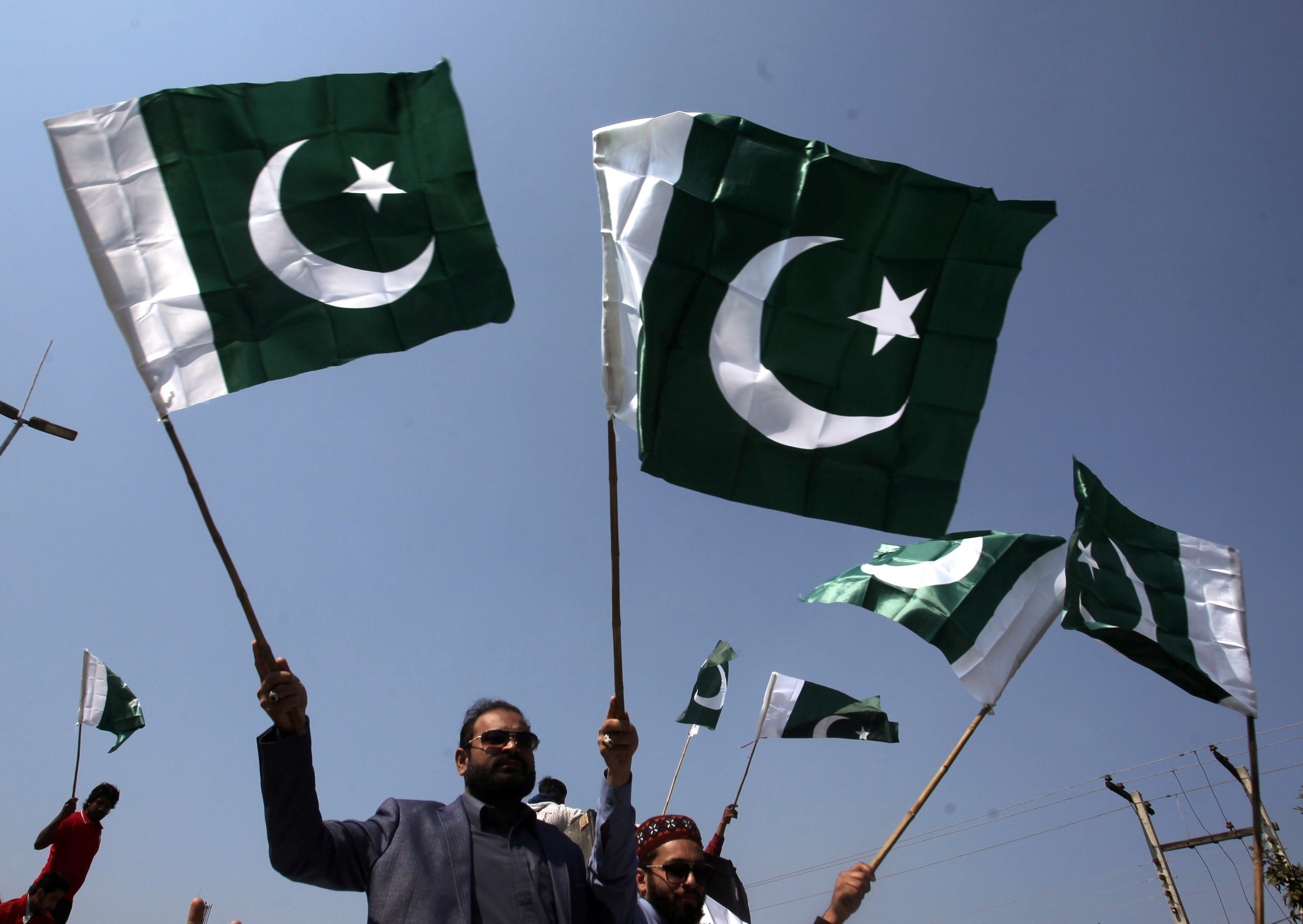 La gente festeggia con le bandiere nazionali dopo che il Pakistan ha abbattuto due aerei militari indiani, Lahore, Pakistan, 27 febbraio 2019. REUTERS/Mohsin Raza