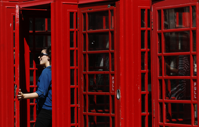 Una donna posa per una fotografia nella tradizionale cabina telefonica inglese, Londra. REUTERS/Luke MacGregor