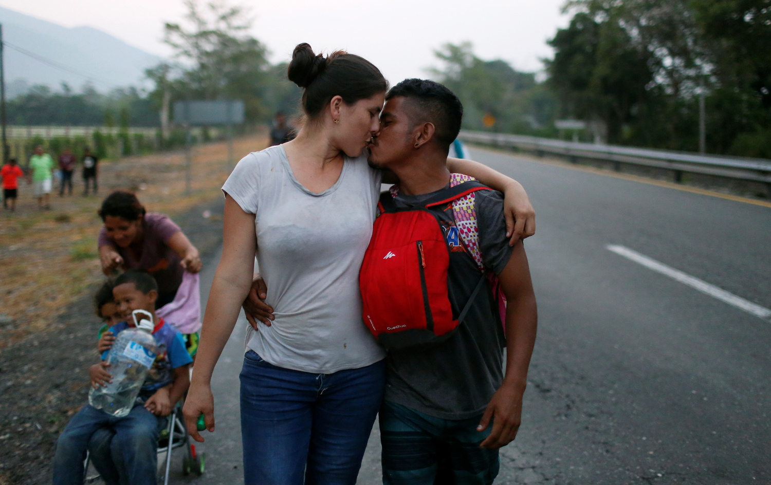 Una coppia di migranti provenienti dall'Honduras si bacia mentre avanza lungo la strada con altri migranti provenienti dall'America centrale durante il loro viaggio verso gli Stati Uniti, Huixtla, Messico, 18 aprile 2019. REUTERS/Jose Cabezas