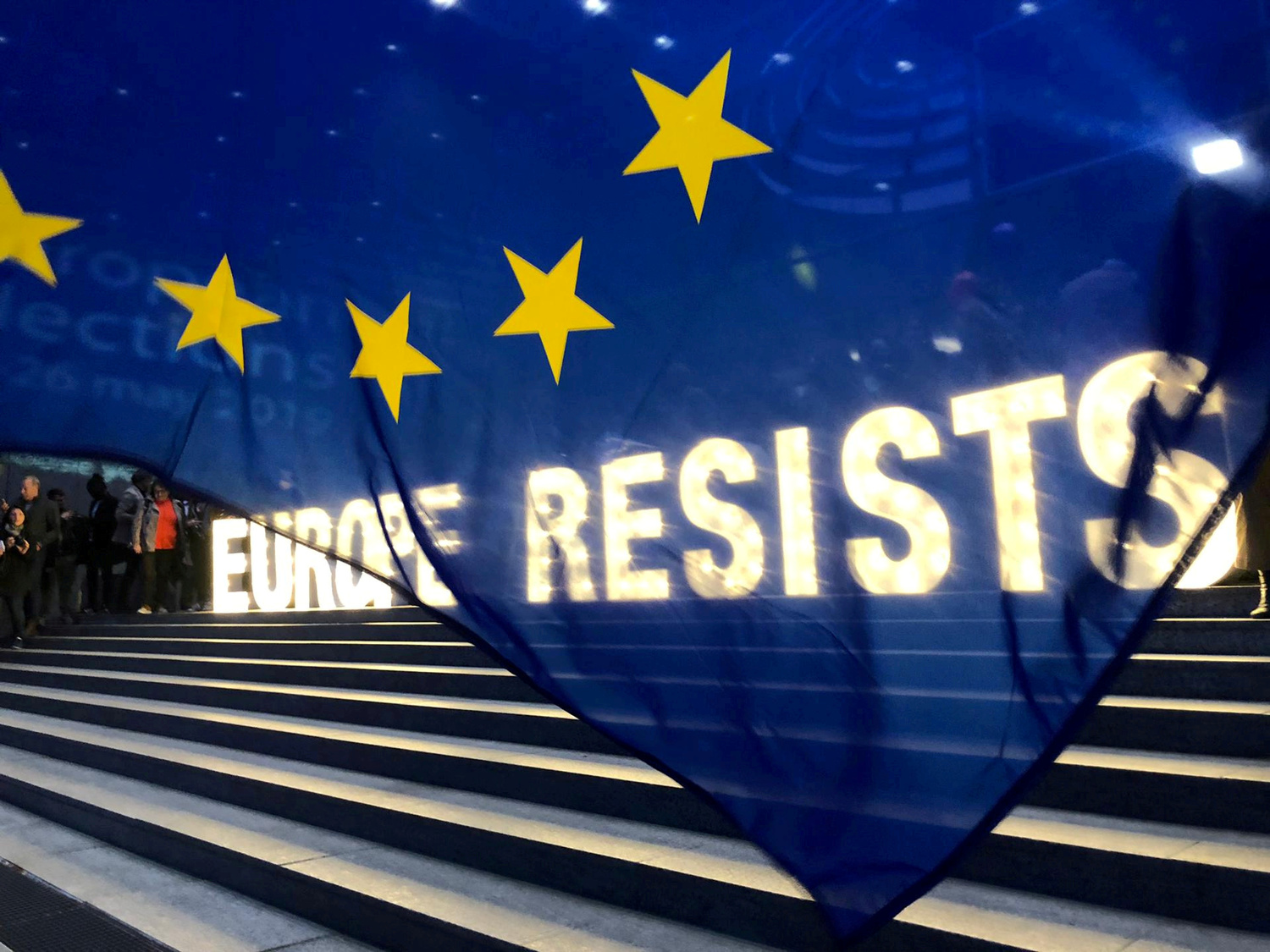 Attivisti mostrano uno striscione al di fuori del Parlamento Europeo durante le elezioni europee a Bruxelles, in Belgio, 26 maggio 2019. Reuters/Bart Biesemans