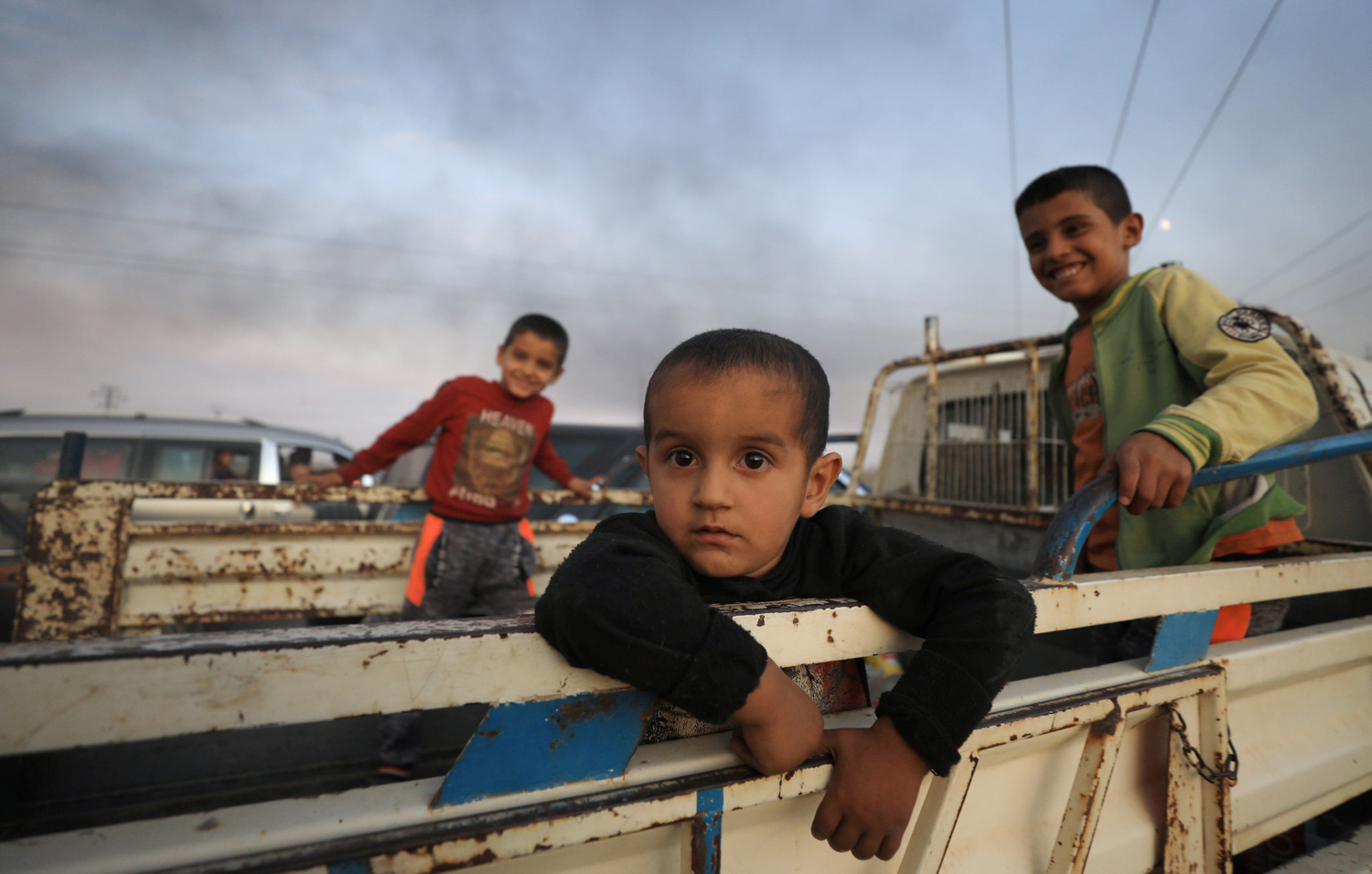 Alcuni bambini stanno sul retro di un camion mentre fuggono dalla città di Ras al Ain, Siria, 9 ottobre 2019. REUTERS/Rodi Said