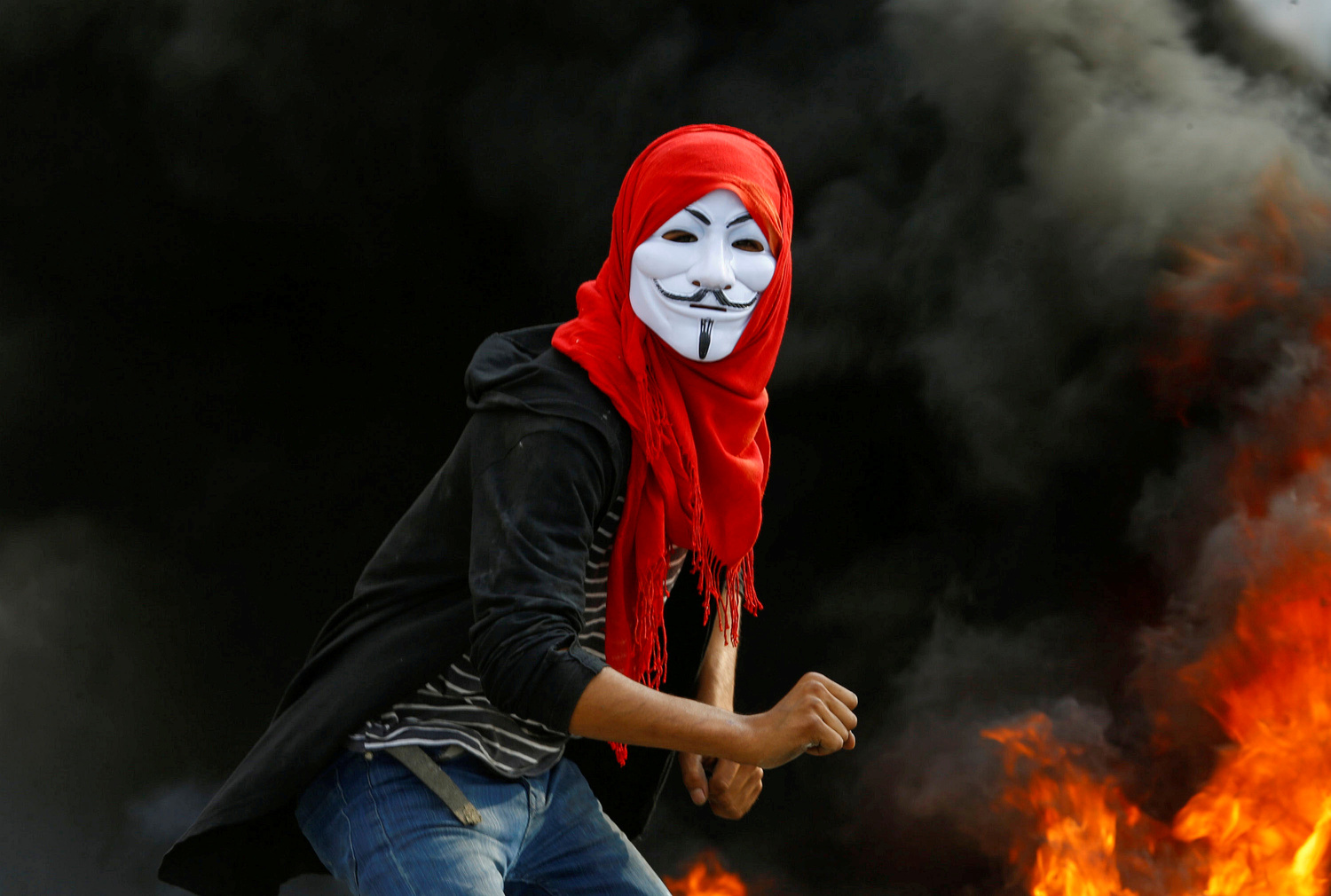 Un manifestante iracheno indossa una maschera durante le proteste antigovernative in corso a Najaf, Iraq, 18 novembre 2019. REUTERS/Alaa al-Marjani