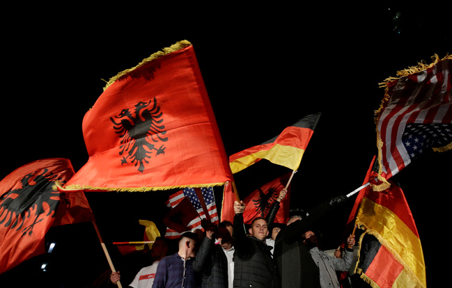 I sostenitori del movimento Vetëvendosje (Autodeterminazione) sventolano bandiere dopo i risultati preliminari delle elezioni parlamentari a Pristina, Kosovo, 7 ottobre 2019. REUTERS/Florion Goga