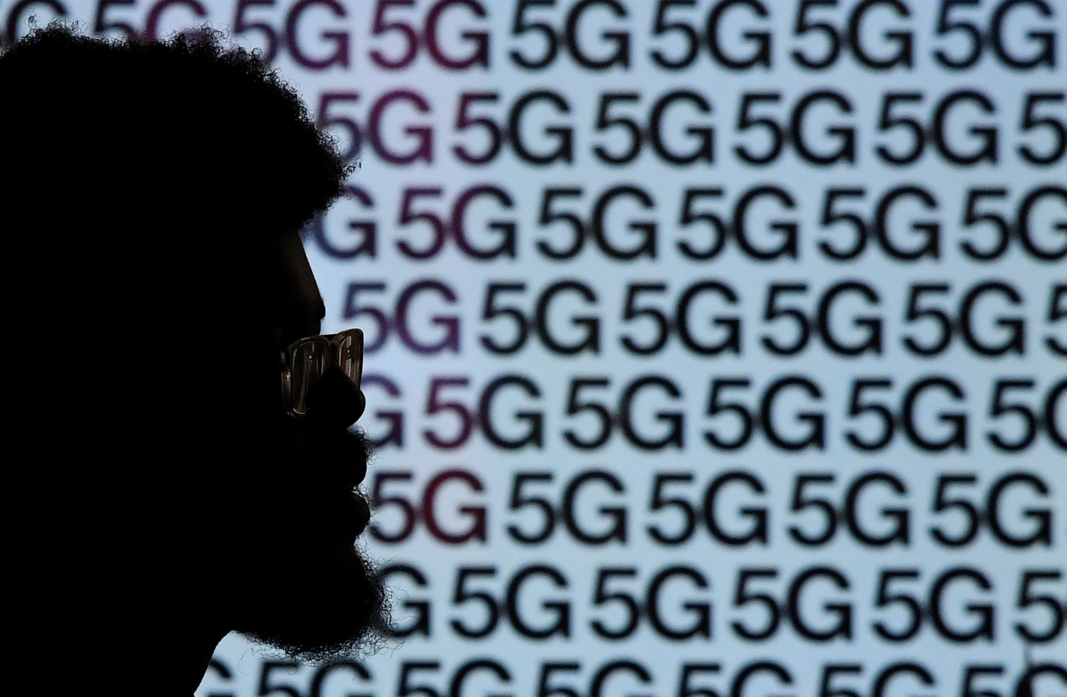 Un uomo passa davanti a un annuncio pubblicitario che promuove la rete dati 5G. REUTERS/Toby Melville