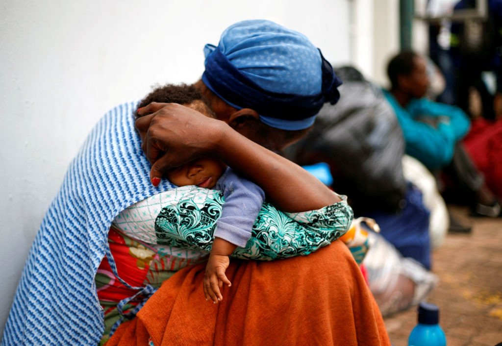 Coronavirus: la chiusura delle frontiere non risolve. Una donna senzatetto fa dormire il suo bambino mentre fanno la fila per essere controllati dal personale sanitario prima di dirigersi verso i rifugi, durante un blocco nazionale di 21 giorni nel tentativo di contenere l'epidemia di coronavirus, a Durban, Sudafrica, marzo 27, 2020. REUTERS/Rogan Ward