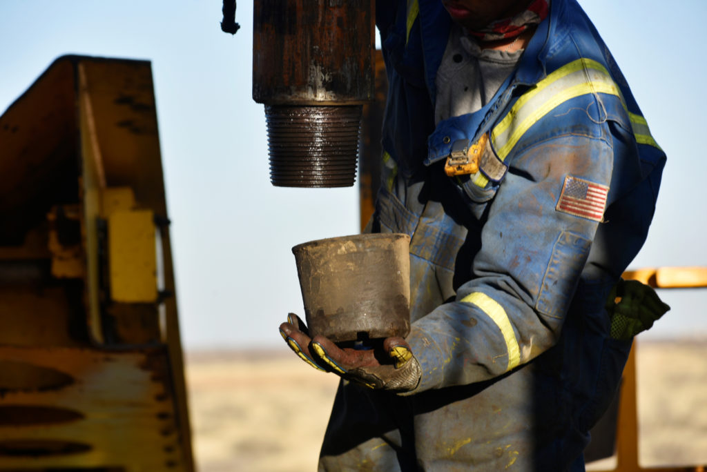 Un operaio petrolifero rimuove un tappo filettato da un pezzo di tubo di trivellazione