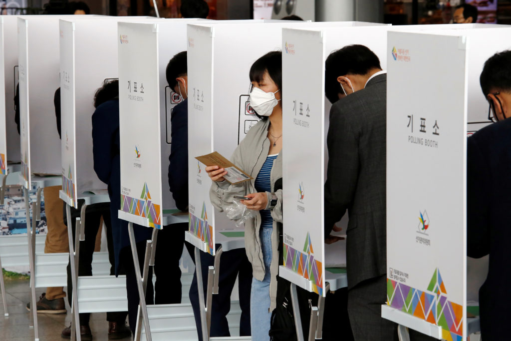 Corea del Sud: il coronavirus non ferma le elezioni. Una donna che indossa una maschera per evitare di contrarre il coronavirus lascia una cabina elettorale per esprimere il proprio voto alle elezioni parlamentari in un seggio elettorale a Seul, Corea del Sud, 10 aprile 2020. REUTERS/Heo Ran